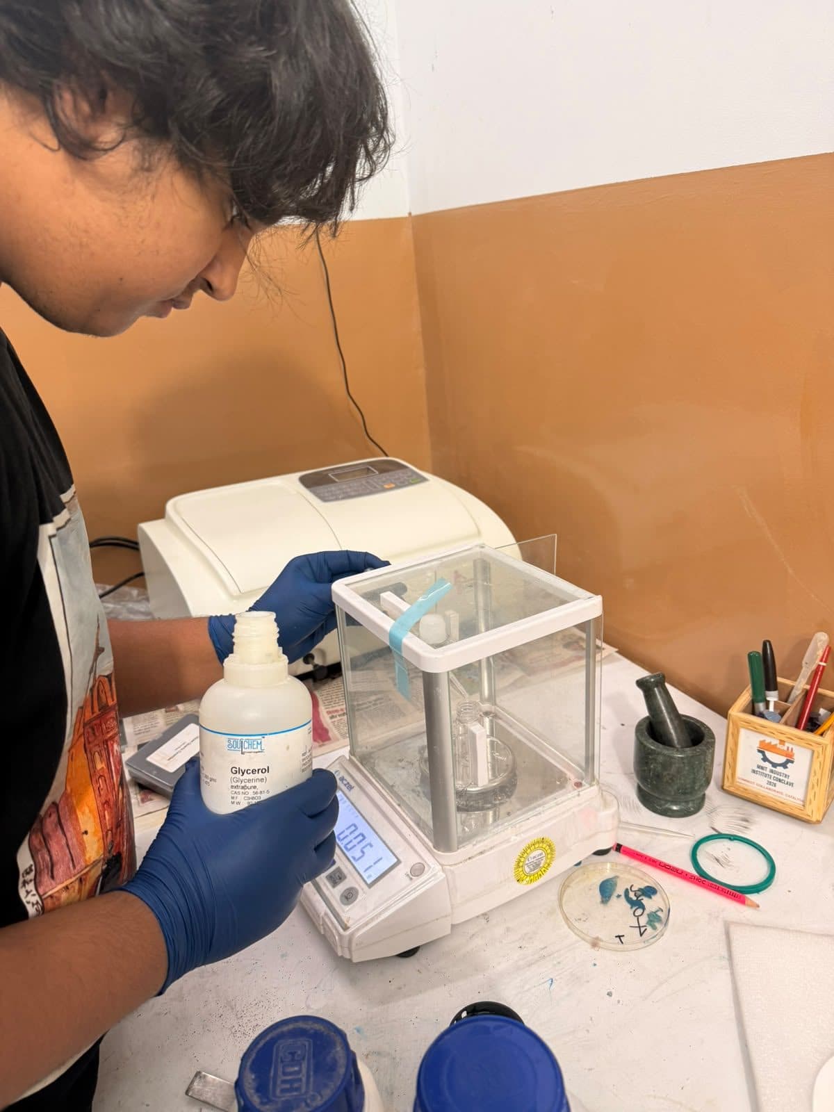 Student measuring a reagent beside an analytical balance