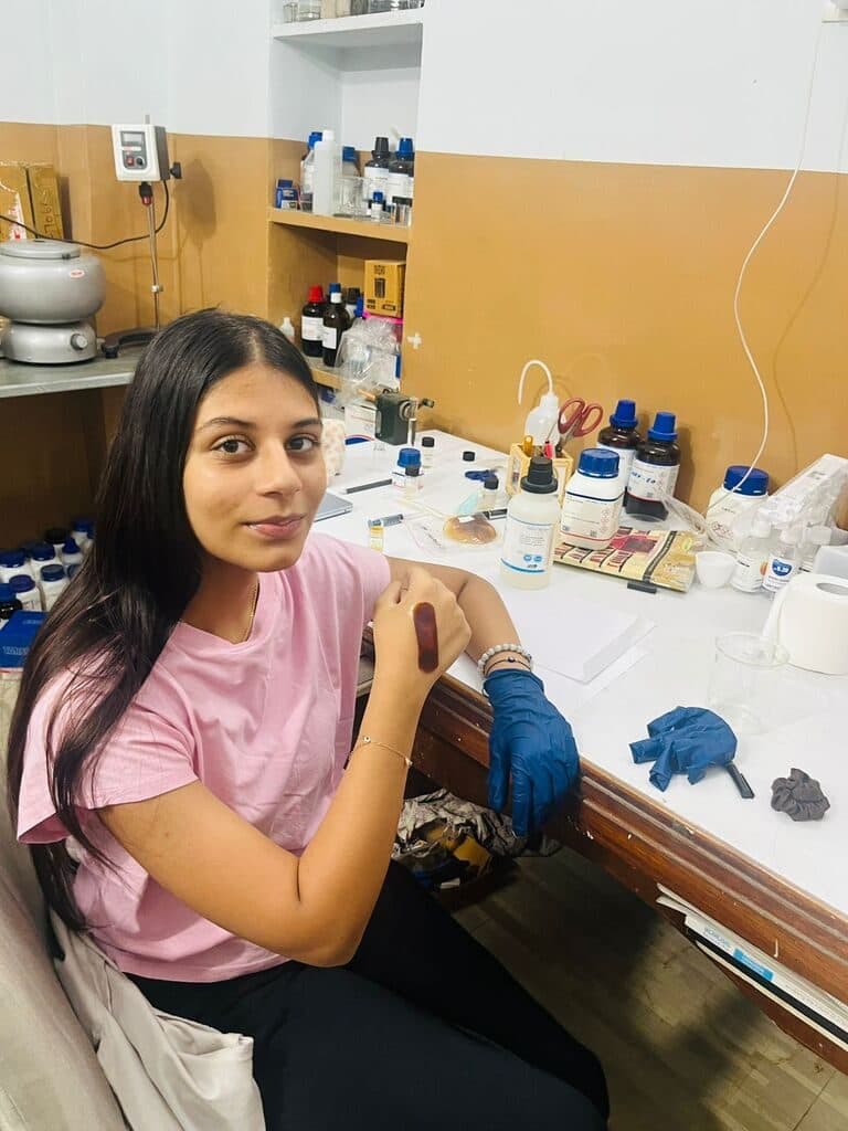Student at the lab bench with a blue material sample