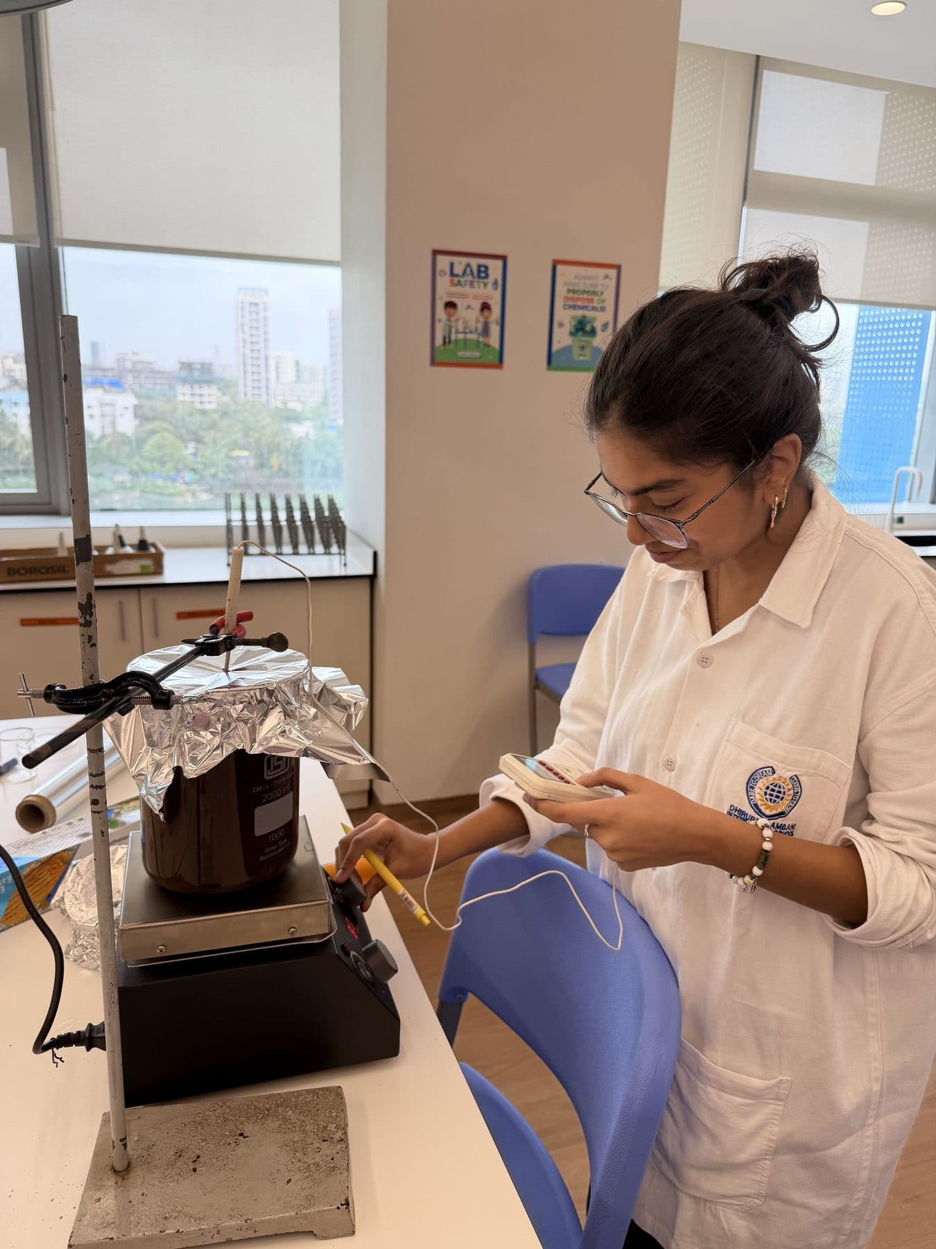Student preparing a foil-covered beaker for a light-sensitive reaction