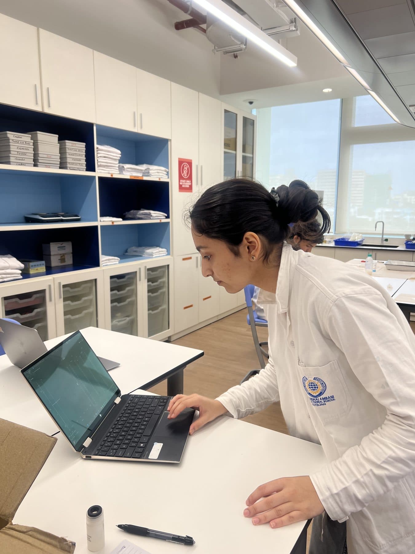 Student writing up research on a laptop in the lab