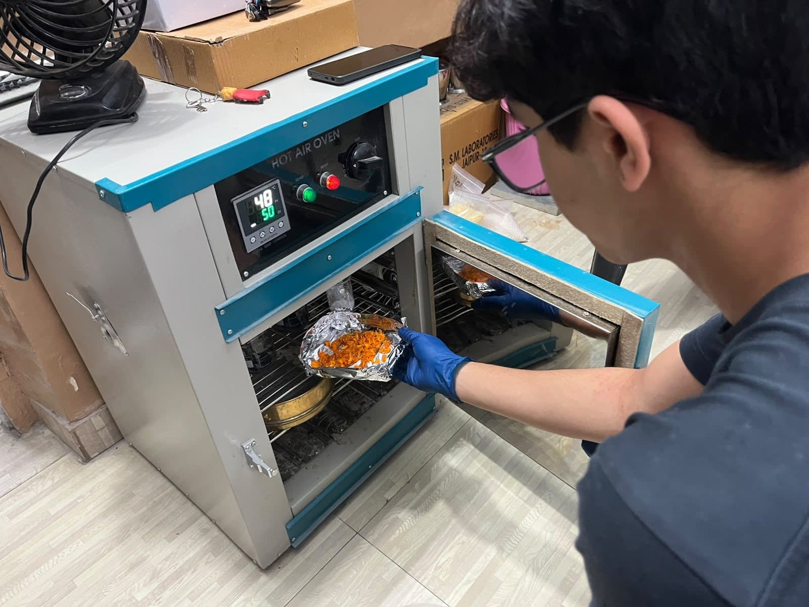Student loading samples into a laboratory oven