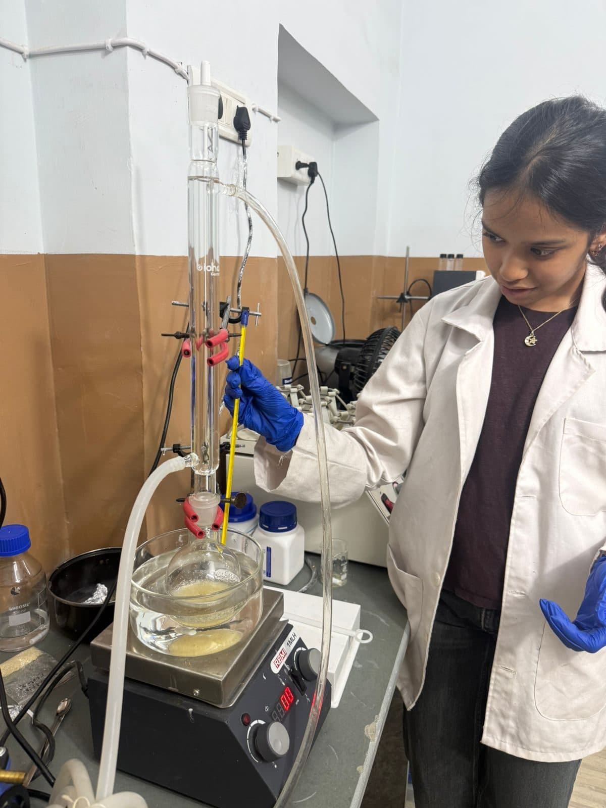Student running a reflux set-up on a hot plate stirrer