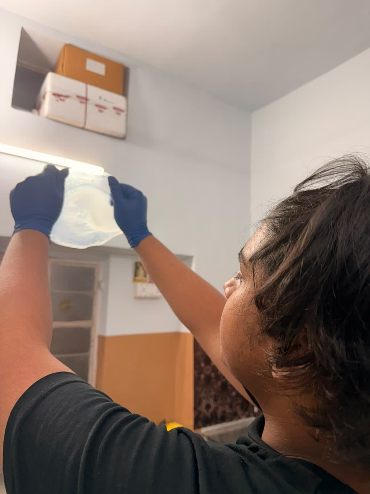 Student holding up a finished sample to the light