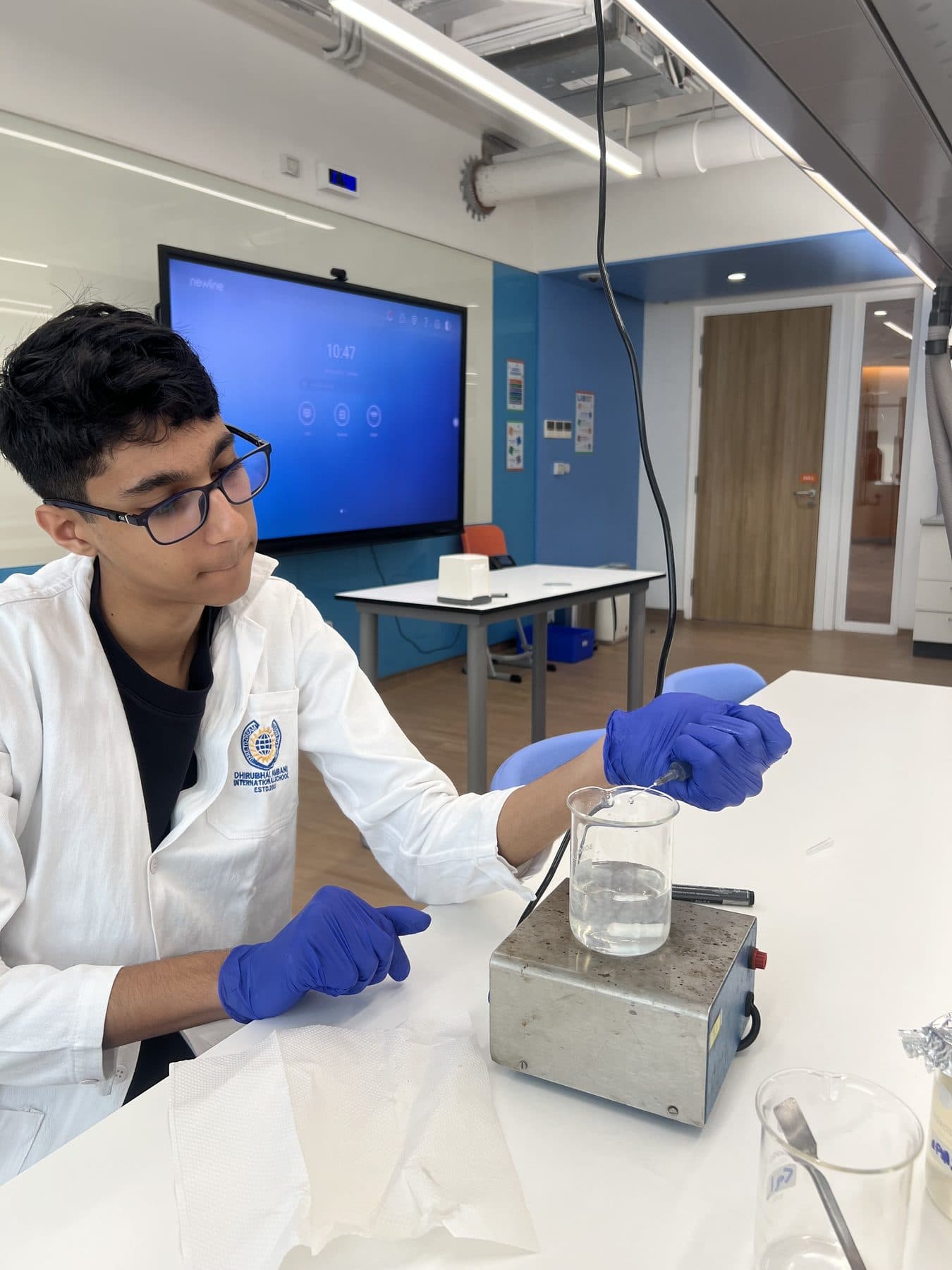 Student checking a beaker on a magnetic stirrer