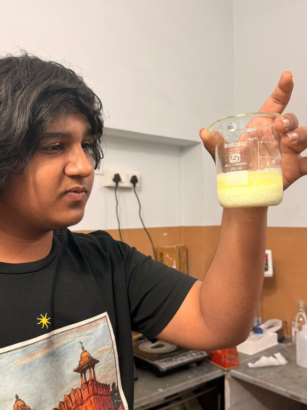 Student checking a yellow mixture in a beaker